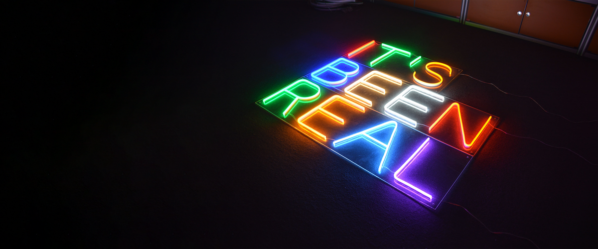 A colorful custom Meon Neon sign glowing in a finished space