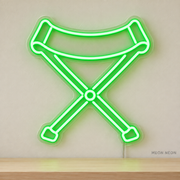 Watermarked concept mockup of Mini Camp Stool LED Neon Sign in Green on a clear acrylic backboard.