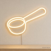 Watermarked concept mockup of Mini Coffee Scoop LED Neon Sign in Warm White on a clear acrylic backboard.