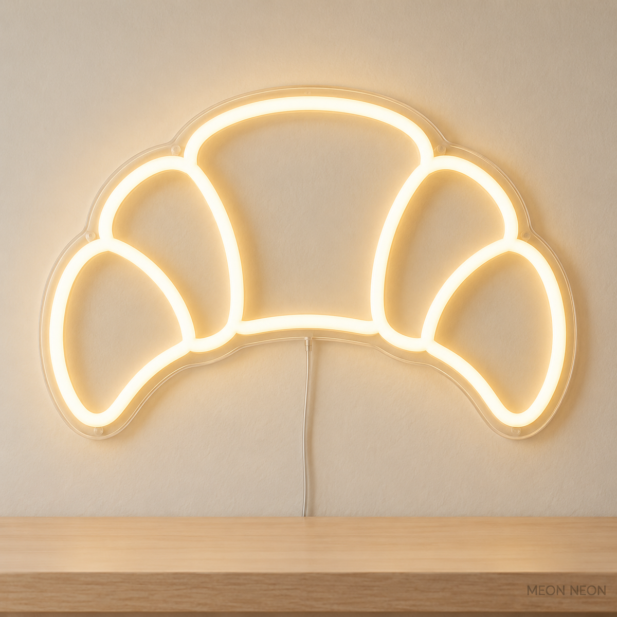 Watermarked concept mockup of Mini Croissant LED Neon Sign in Warm White on a clear acrylic backboard.