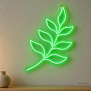 Watermarked concept mockup of Mini Fern Frond LED Neon Sign in Green on a clear acrylic backboard.