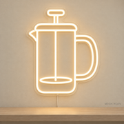 Watermarked concept mockup of Mini French Press LED Neon Sign in Warm White on a clear acrylic backboard.