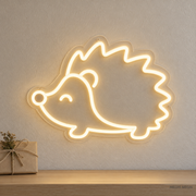 Watermarked concept mockup of the Mini Hedgehog LED Neon Sign in Warm White on a clear acrylic backboard.