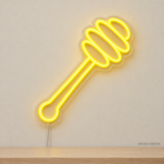 Watermarked concept mockup of Mini Honey Dipper LED Neon Sign in Yellow on a clear acrylic backboard.