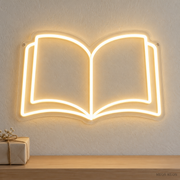 Watermarked concept mockup of the Mini Open Book LED Neon Sign in Warm White on a clear acrylic backboard.