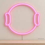 Watermarked concept mockup of Mini Pilates Ring LED Neon Sign in Pink on a clear acrylic backboard.