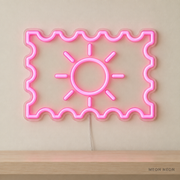Watermarked concept mockup of Mini Postage Stamp LED Neon Sign in Pink on a clear acrylic backboard.