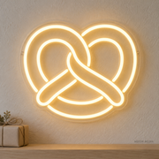 Watermarked concept mockup of the Mini Pretzel LED Neon Sign in Warm White on a clear acrylic backboard.