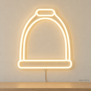 Watermarked concept mockup of Mini Stirrup LED Neon Sign in Warm White on a clear acrylic backboard.